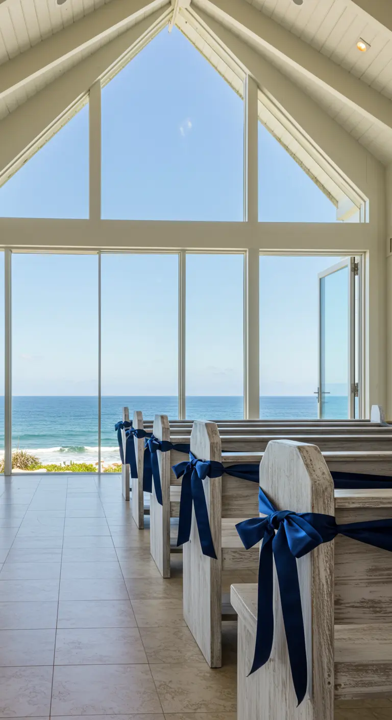 Bancos de madera envejecida en una capilla con vistas al mar, decorados con lazos azules.