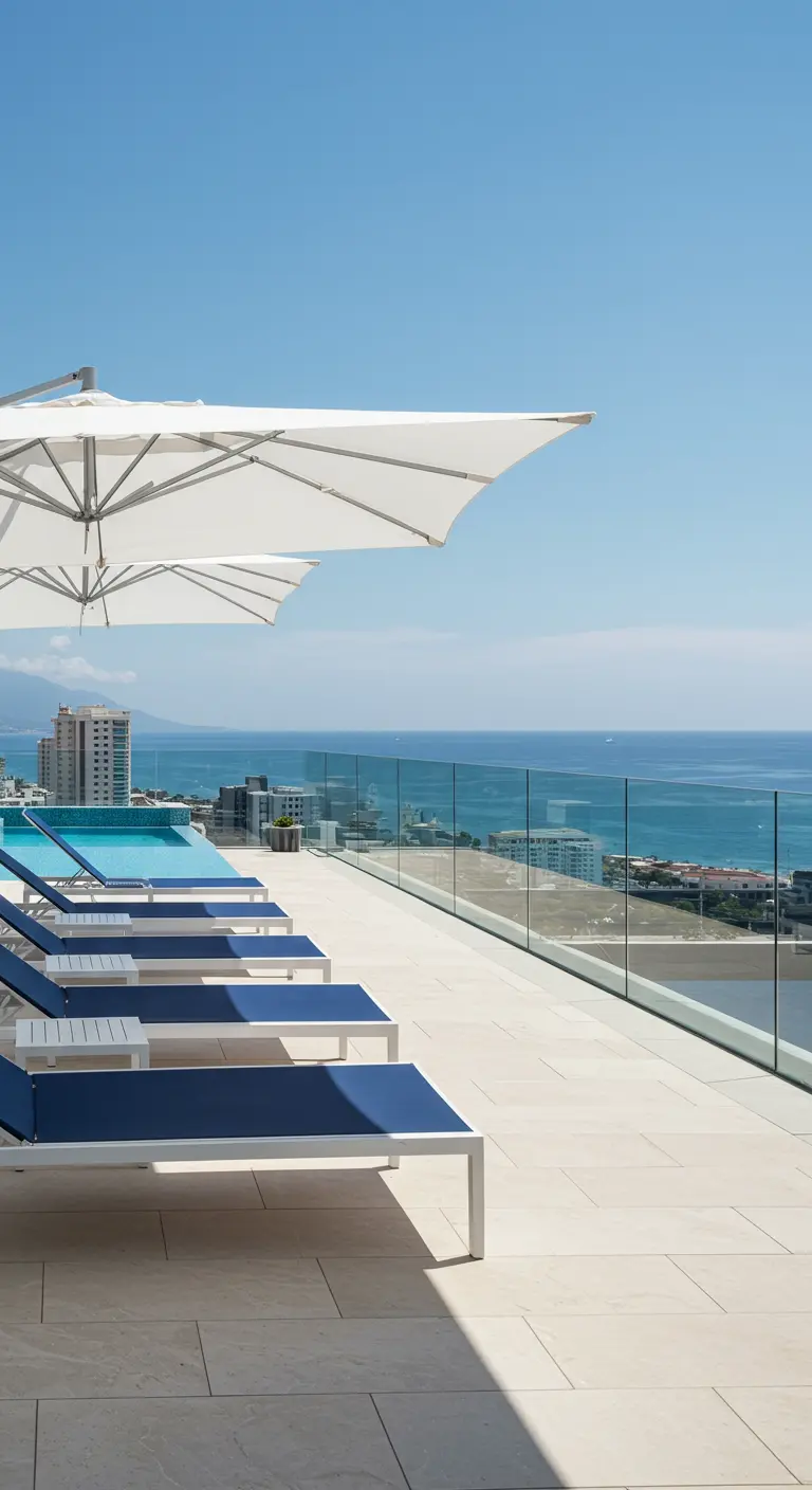 Terraza soleada con tumbonas azules y blancas junto a una piscina con vistas al mar