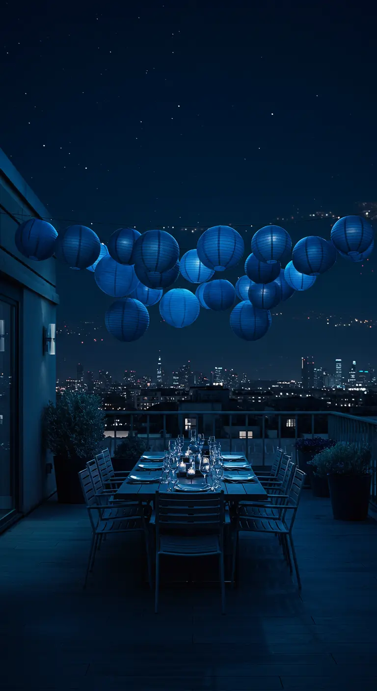 Terraza con vistas a la ciudad iluminada por un conjunto de lámparas de papel azules sobre una mesa