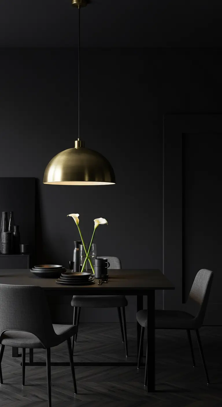 Comedor minimalista oscuro con una lámpara de cúpula de latón sobre una mesa negra.