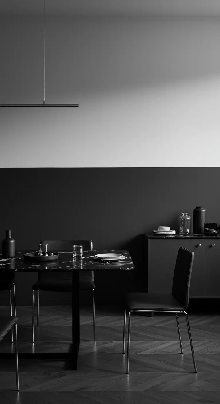 Comedor minimalista con pared dividida en negro mate y gris claro, y mesa de mármol negro.