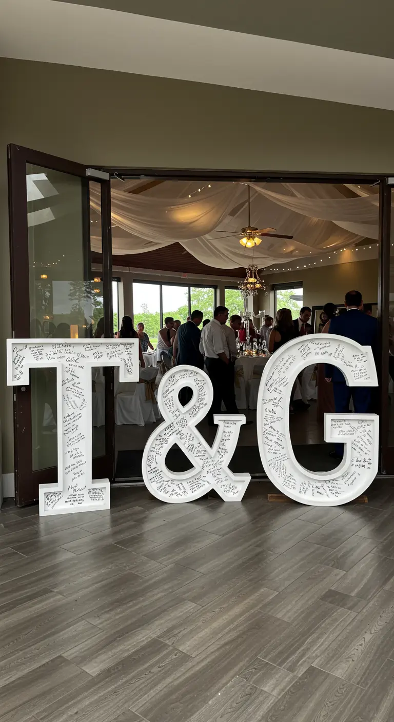 Iniciales blancas gigantes 'T & G' cubiertas con firmas y mensajes de los invitados de la boda.