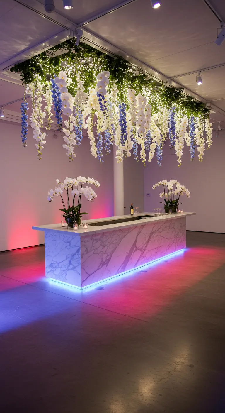 Barra de mármol moderna con una instalación floral de orquídeas blancas y azules colgando del techo.