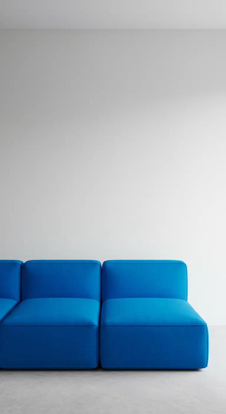 Sofá modular de líneas simples en un llamativo color azul cobalto contra una pared blanca.