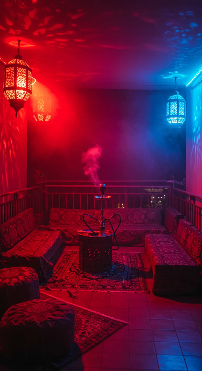 Balcón decorado al estilo árabe con sofás bajos, una cachimba y una atmósfera roja y azul creada por luces