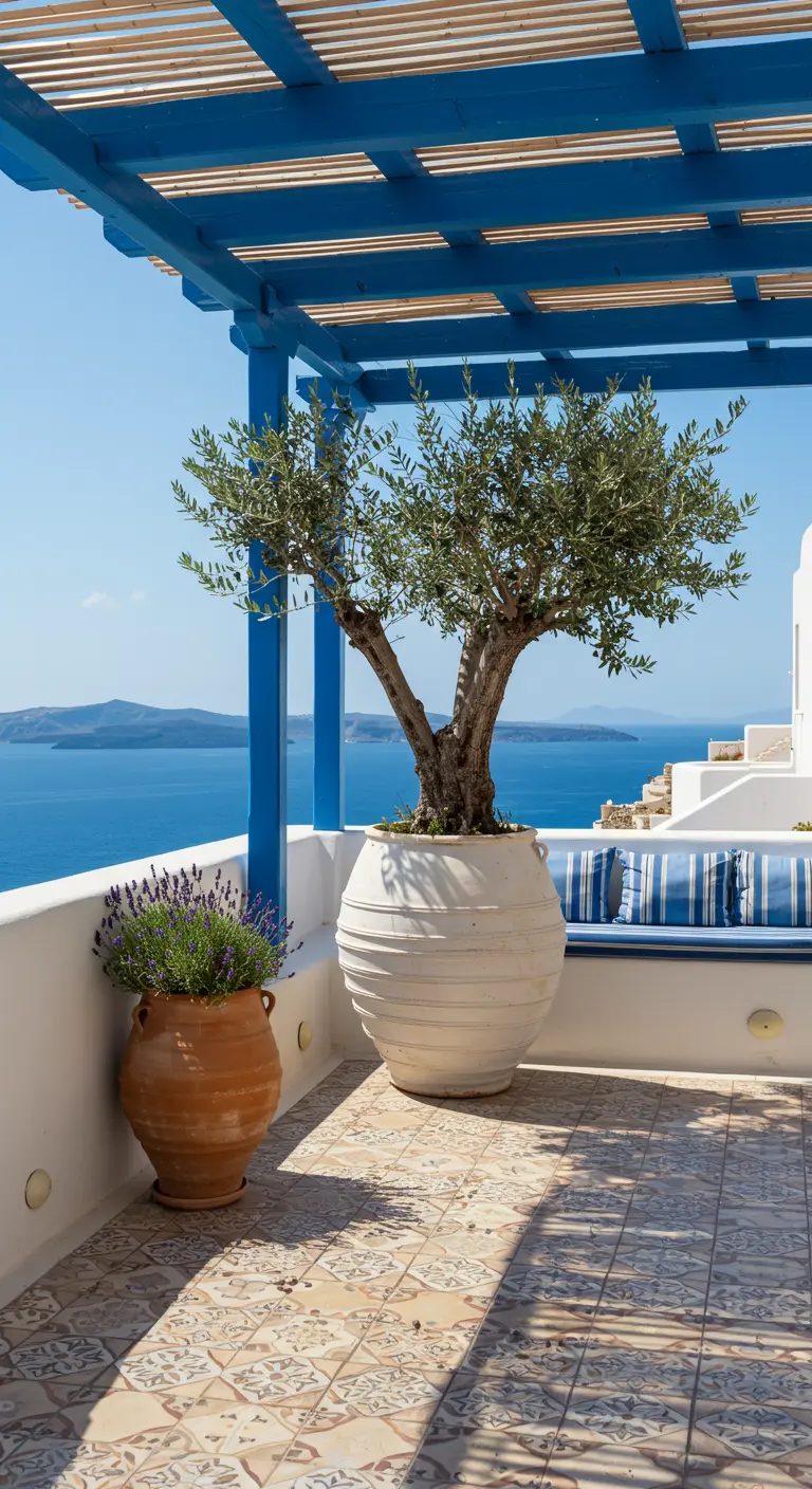 Balcón mediterráneo con una pérgola de madera azul, un olivo en maceta blanca y vistas al mar.