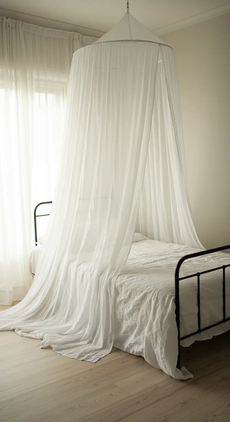 Cama con dosel DIY hecho con tela de visillo blanca que cae desde el techo.