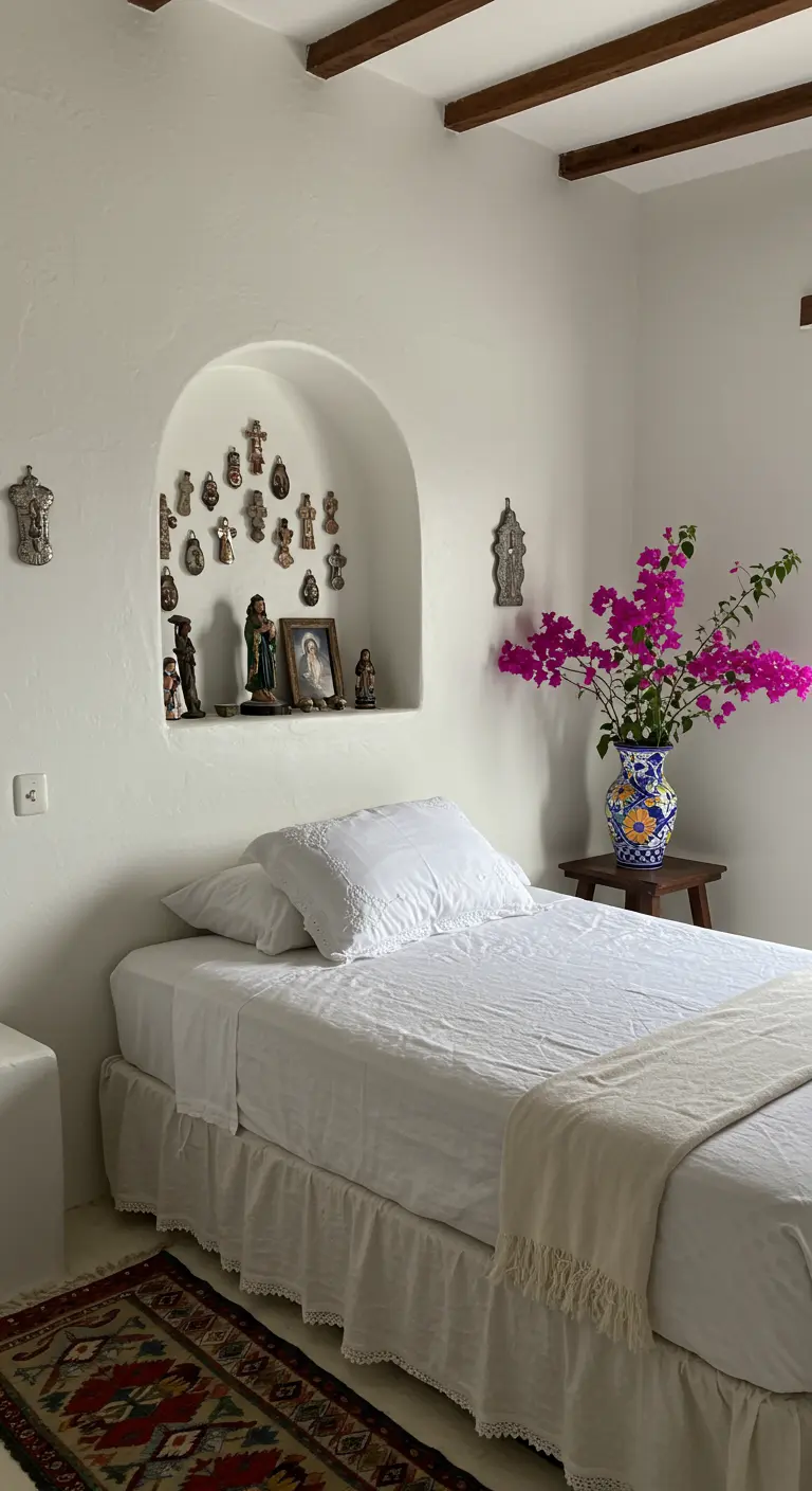 Nicho en la pared de un dormitorio blanco con una colección de pequeñas figuras religiosas.