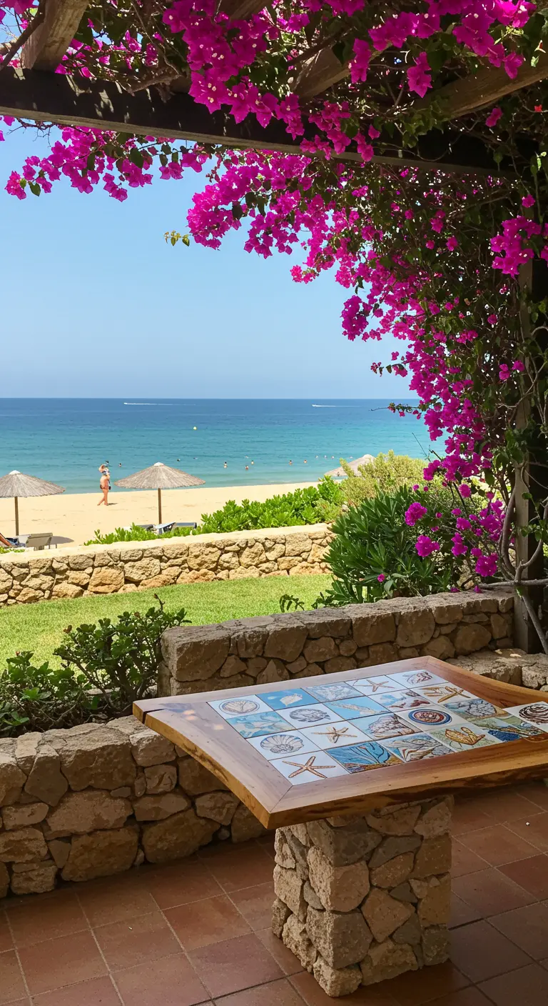 Mesa de exterior con tablero de mosaico de azulejos con motivos marinos, con vistas a la playa.